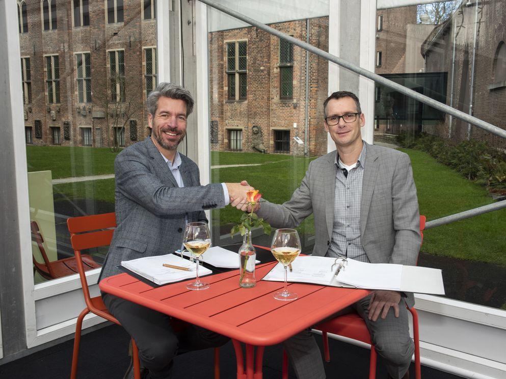 Marco Grob (links) en Erik de Ruiter (rechts) ondertekenen de onderhoudsovereenkomst